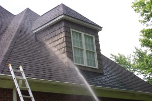 Rinsing a roofline and gutter area from a ladder